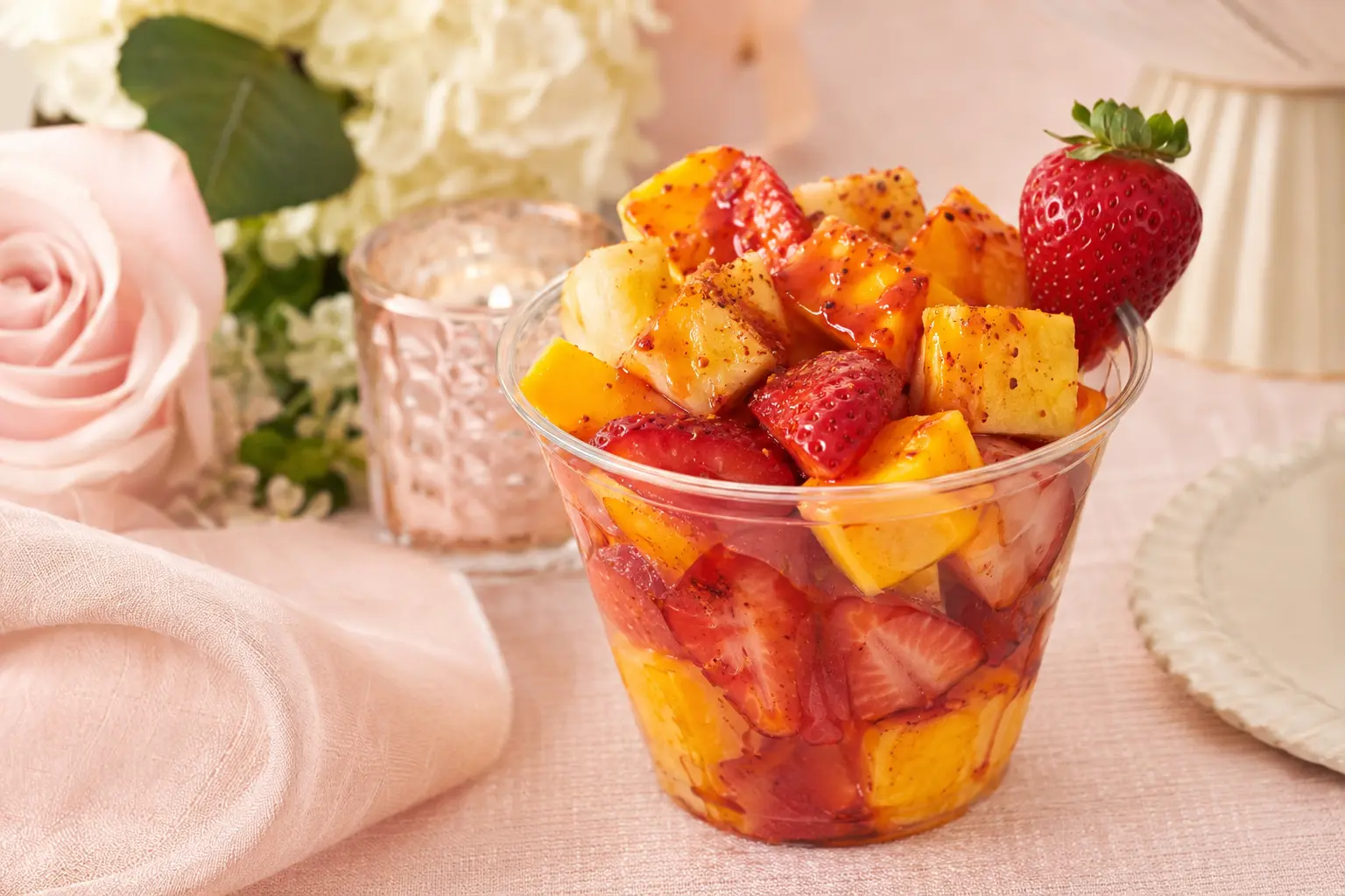 Fresh strawberry, mango, and pineapple fruit cup with chamoy